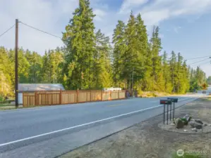 View of both of the parcels entrances from Grapeview Loop Road. Waterfront home on the left, vacant land on the right