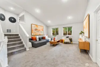 Upper level living room and stairs that lead up to primary suite