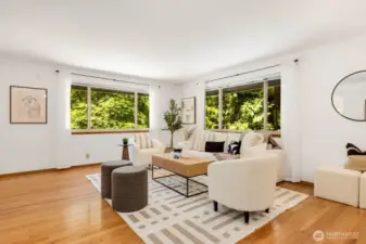 Bright living room, surrounded by windows. No neighbors peaking into your home, just plenty of light, plenty of trees at every turn