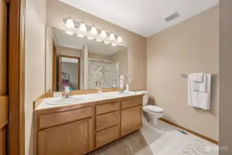 Primary bathroom with dual sinks and walk in closet.