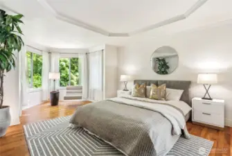 The primary bedroom is a true luxurious retreat with a sitting area and serene views of the backyard.
