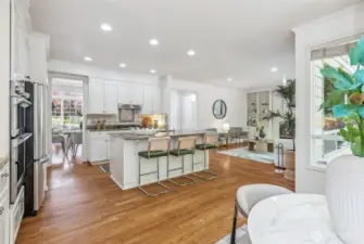 The kitchen is a standout, showcasing a new built-in oven and microwave, stainless steel appliances, spacious granite countertops, crisp white cabinetry, a gas range, a full-height backsplash, and a pantry.