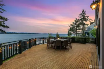 Expansive deck seen at twilight just off the kitchen and dining areas