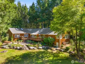 What a beautiful setting. Perennial beds and rock hardscape. Fire pit, and sunny lawn is a good balance with the wooded trails. Very private setting.