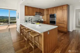 Gorgeous epicurean kitchen features Wolf 6 burner range, premium cabinetry with custom pull-outs and natural entended slab counters.