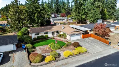 Nice rambler with tailored front yard landscaping, complete with a flagpole .... note the covered RV parking on the right side of home...it can handle a tall vehicle