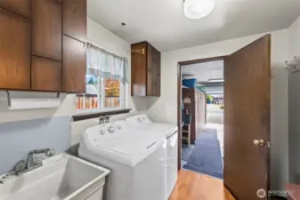 Large laundry/mud room with utility sink and extra storage. Newer washer and dryer stay with the home.
