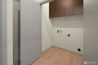Dedicated laundry room with built-in storage cabinets and plenty of workspace.