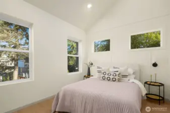 Bright and airy primary bedroom featuring large windows and clean modern lines.