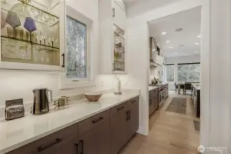 A well-appointed butler’s pantry offers seamless flow into the kitchen, featuring additional prep space, cabinetry, and a walk-in pantry for exceptional storage. Perfect for entertaining and everyday convenience.