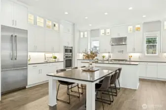 The thoughtfully designed chef’s kitchen features Thermador appliances, abundant custom cabinetry, and sleek quartz surfaces that blend beauty with functionality. An expansive island with seating provides the perfect hub for entertaining, meal prep, and everyday gathering within the open-concept main level.