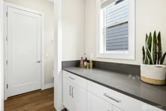 Conveniently located just off the attached two-car garage, the mudroom offers built-in cabinetry and generous counter space for everyday organization. Durable finishes and thoughtful storage solutions create a practical drop zone that keeps the main living areas effortlessly tidy.