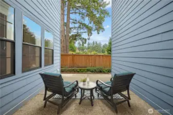 Just off the dining room, this private patio creates a perfect extension of the indoor living space. Framed by the home’s clean architectural lines, the intimate setting is ideal for morning coffee, evening wine, or quiet conversation.    Low-maintenance concrete hardscaping, privacy fencing, and peaceful views of mature evergreens provide a serene backdrop, making this a cozy outdoor retreat tucked just steps from the heart of the home.
