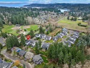 Elevated aerial view showcasing the home’s proximity to Rotary Park and the surrounding neighborhood. Eagle Harbor shimmers in the distance, highlighting the island setting and natural beauty that define Bainbridge living.