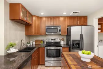 The updated kitchen has several extra features, a wine fridge, a free-standing wood top prop island, newer cabinets, and stainless appliances.