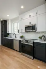 Experience the perfect blend of style and functionality in this kitchen, featuring light upper cabinets and dark lower cabinets, complemented by transom cabinets above for added storage.