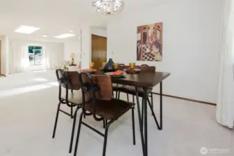 The dining room blends into the formal living room, light filters in through the skylights and large windows. Entertain with ease, just a few steps to the kitchen.