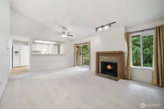 Bright and open living room with vaulted ceilings. A cozy fireplace adds warmth and charm.