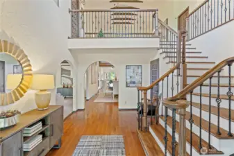Breathtaking entryway showcases the beautiful wood and iron banisters and towering ceilings.