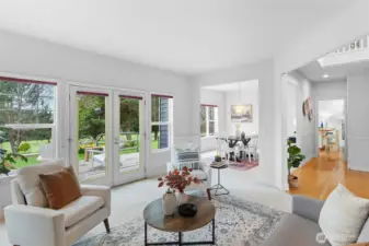 Living room passes through to formal dining room and hall to coat closet, powder room, and kitchen/family room.