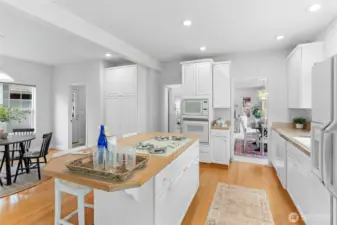 Open space kitchen work area, breakfast bar, dining area, and cooktop kitchen island.