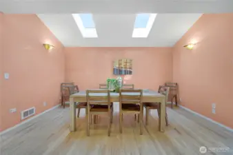 Bright Dining area with skylights directly off kitchen with access to back deck and yard