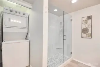 Remodeled bathroom with framless shower door, pepple floor, and tiled shower.