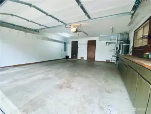 Large two car garage with built in shelving for storage.