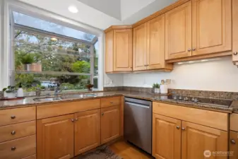The updated kitchen has an electric cooktop and a separate wall oven with a built-in microwave with a lot of cabinet and countertop storage.