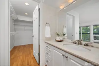 There is a large walk-in closet with additional storage space on the other side of the vanity.