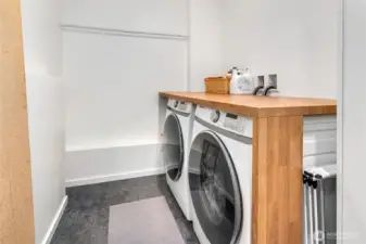 Laundry room downstairs with storage room.