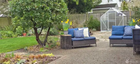 The back yard offers an oversized aggregate concrete patio, Flagstone pathways and patio, grassy area, delightful gardens, greenhouse and two sheds.  This yard created over the past 54 years shows creativity and a love for gardening making this space truly magical.