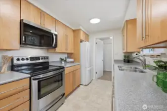 Upgraded maple cabinets & hardware, pantry not pictured, Stainless Steel range, microwave & dishwasher plus great refrigerator, newer counters, and new light fixtures make this kitchen ready for your chef skills!  Plenty of counterspace and access to 3/4 bath with laundry, door to your backyard oasis and or leads upstairs to your 1/2 story, quaint 3rd bedroom.  Also leads to the secondary living room space creating a functional, circular floor plan!