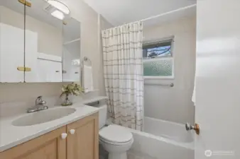 One of two bathrooms.  This is the full bath with tub/shower combo, updated cabinets and located just outside the 2 main floor bedrooms.  Light & bright!