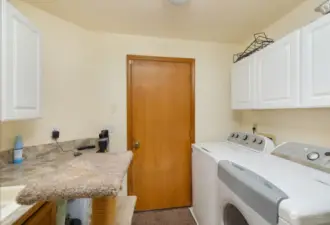 Large laundry room with storage and access to the two-car garage