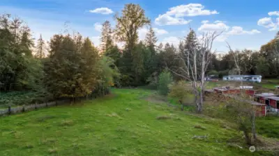 A seasonal creek follows the tree line to the right, just left of the barn