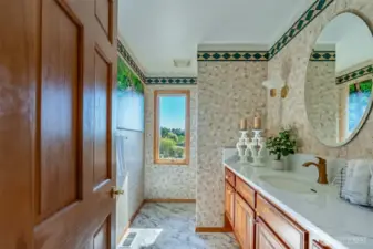This well-appointed guest bath features timeless finishes, a generous countertop, and a perfectly placed window framing peaceful treetop views—blending charm and comfort.
