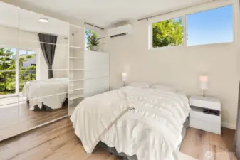 Primary bedroom with wall of mirrored storage closets