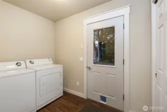 laundry room off the kitchen, with storage closet and door to back yard & off street parking.