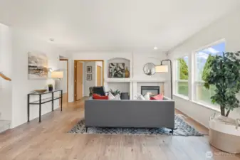 A centered fireplace anchors this comfortable gathering space, creating a natural focal point for everyday living. The layout easily accommodates full-size seating while keeping pathways open to adjacent rooms.