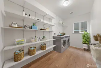 This main-level utility room is virtually staged to showcase its impressive storage potential with extensive shelving and workspace options. The spacious layout easily accommodates full-size laundry appliances while keeping everything organized and accessible.