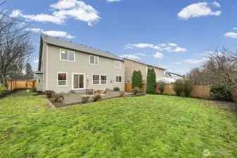 An expansive grassy yard offers room to relax, entertain, or customize your outdoor vision. The fence line and surrounding greenery define the space while keeping it open and usable.