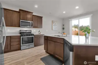 Kitchen view two, I love that the sink is on your huge island, open concept to your dining area and large patio doors.