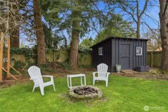 Lovely firepit area and handy storage shed in the backyard