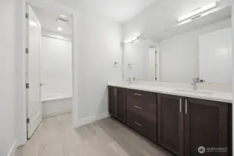 Main bath with double sinks and separate tub/toilet area to make sharing easy.
