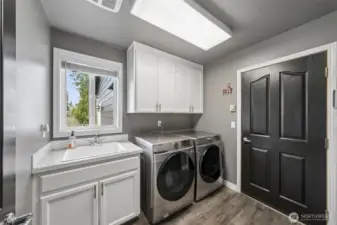 Main level laundry area located just off the attached 3 + car garage. LVP flooring, Culligan water purification system throughout this home + plenty of storage & deep sink!