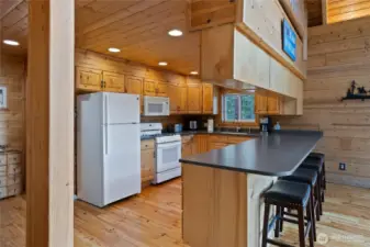 Large kitchen features tons of cabinetry & island seating.