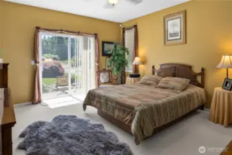 Primary bedroom features a private slider out to the backyard oasis and ceiling fan.