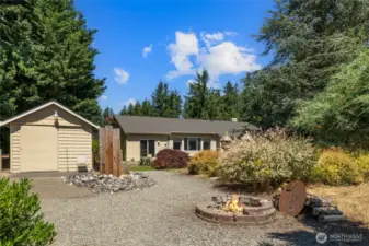 View from your back yard with extra gravel area perfect for your outside firepit area and looking back towards the detached shop/shed that has HOT Water and Electricity!