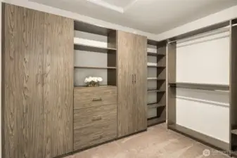 Primary suite walk-in-closet has built-in organizers, shelves, hanging space, and drawers.